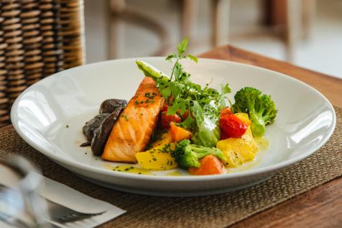 a plate of food with fish and vegetables on a table at Slaviero Ingleses Convention in Florianópolis