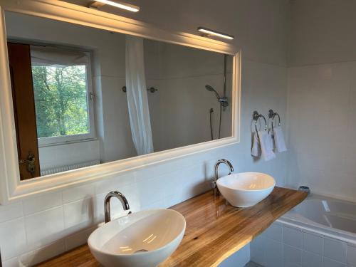 a bathroom with two sinks and a mirror and a tub at Haus mit Garten in Eugendorf
