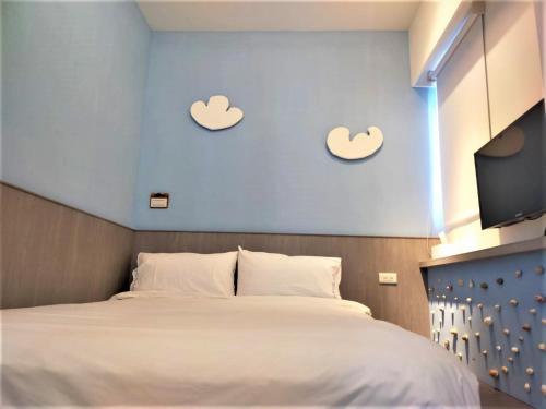 een slaapkamer met een bed met twee harten aan de muur bij 棉花雲文旅民宿B&B in Ch'ao-yang