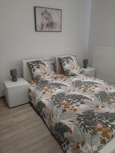 1 cama con edredón de flores en un dormitorio en Le sommet du Condroz, en Ciney