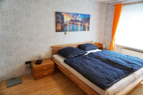 a bedroom with a bed with a blue comforter at Ferienwohnung-Daaden in Daaden