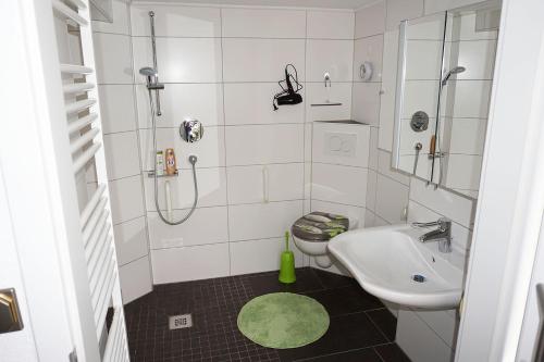 uma casa de banho branca com um lavatório e um WC em Ferienwohnung-Daaden em Daaden