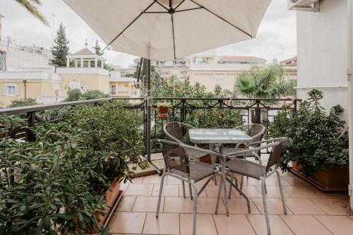 a balcony with an umbrella and a table and chairs at Villa Luigi XVI in Taranto