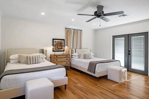 a bedroom with two beds and a ceiling fan at The Olive Branch - Hot Tub & Walk to Main in Fredericksburg