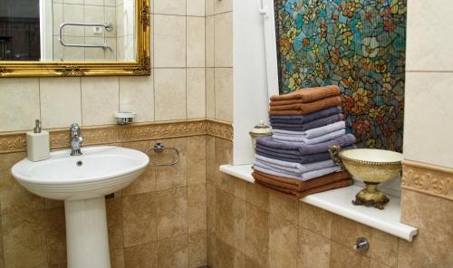 a bathroom with a sink and a pile of towels at Villa Del Mar in Jūrmala