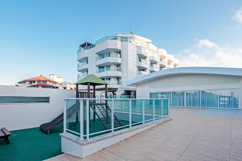 a apartment building with a playground in front of it at Slaviero Ingleses Convention in Florianópolis