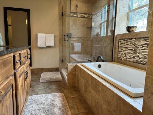 La grande salle de bains est pourvue d'une baignoire et d'une douche. dans l'établissement Private Retreat on Working Horse and Cattle Ranch, à Salida