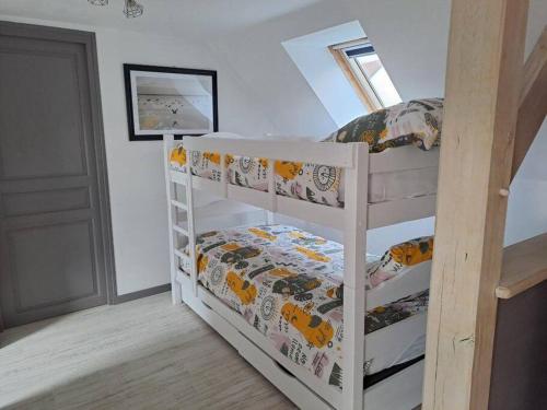 a bedroom with two bunk beds in a attic at Gîte Les Pareurs in La Ferté-Macé