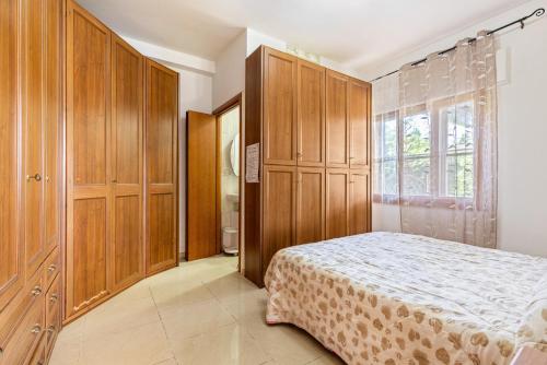 a bedroom with wooden cabinets and a bed at Casa Marina in Rosolina