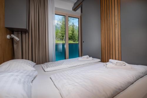 2 camas en una habitación de hotel con ventana en TATRYSTAY Bernard Apartments, en Nový Smokovec