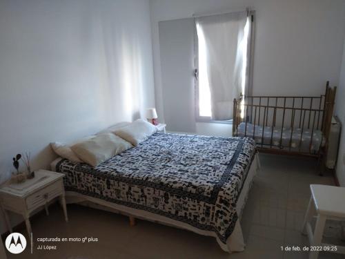 a bedroom with a bed and a window and a crib at Belvedere in Puerto Madryn
