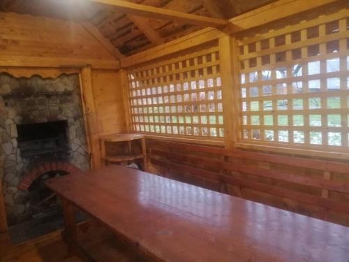 a wooden table in a room with a fireplace at Садиба Криниченька in Yaremche