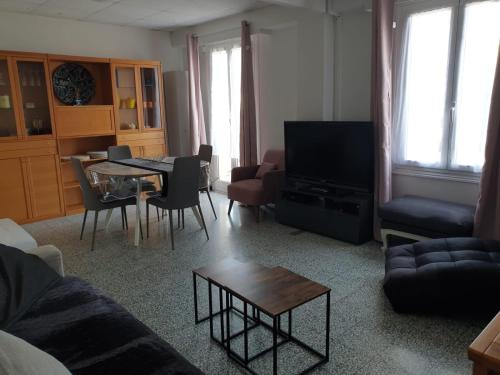 Villa Angelina في بوسولاي: غرفة معيشة مع أريكة وطاولة وتلفزيون