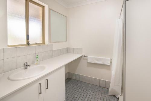 a white bathroom with a sink and a shower at Riverscape Cottages in Augusta