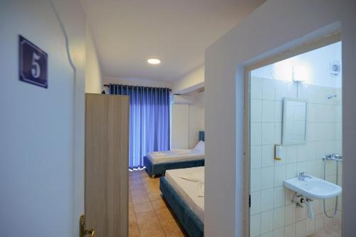Habitación con baño con cama y lavabo. en Mema Hotel en Himare