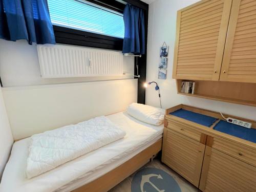 um pequeno quarto com uma cama e uma janela em Ferienpark Sierksdorf App 202 - Strandlage em Sierksdorf