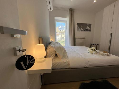 a bedroom with a bed with a lamp and a window at V12 Apartments Puglia Modugno in Modugno