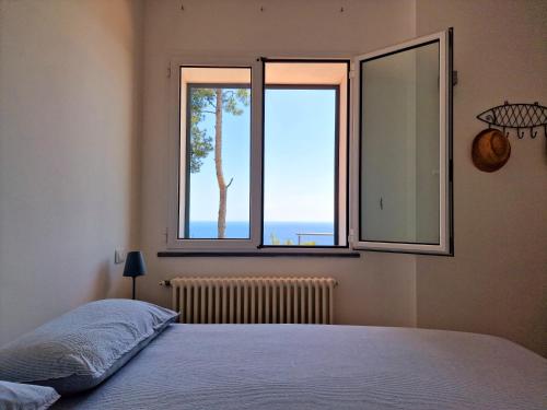 a bedroom with a bed and a window with a view at Appartamento in Villa Mimosa in Cervo