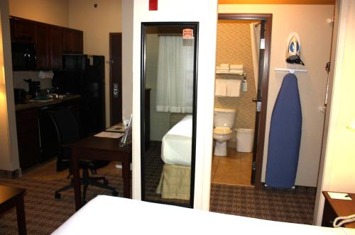 two pictures of a hotel room with a bathroom at MainStay Suites St Robert - Fort Leonard Wood in Saint Robert
