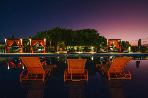 two chairs sitting in a pool at night at Slaviero Ingleses Convention in Florianópolis