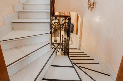 a hallway with white stairs with black and white flooring at Villa Luigi XVI in Taranto
