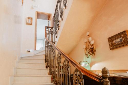 a staircase in a home with white walls and wooden railings at Villa Luigi XVI in Taranto