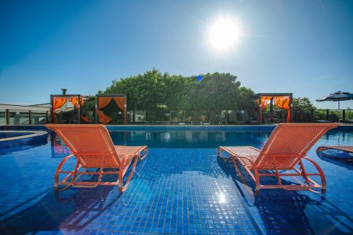 two chairs sitting next to a swimming pool at Slaviero Ingleses Convention in Florianópolis