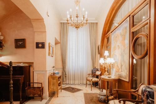 a living room with a chandelier and a table and chairs at Villa Luigi XVI in Taranto