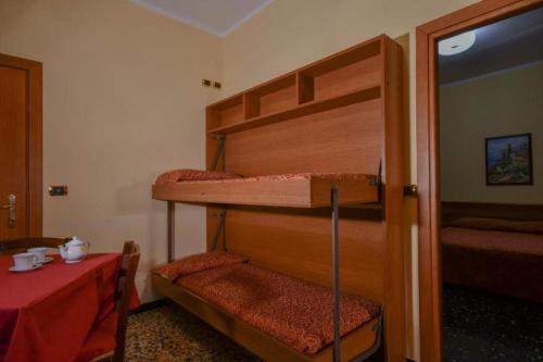 2 literas en una habitación con mesa y puerta en Residence Paradiso Bilocale 204, en Moneglia