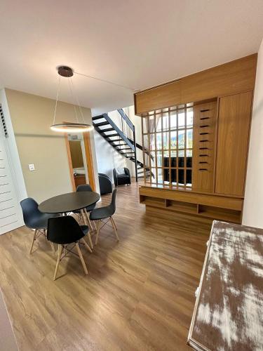 a dining room with a table and chairs and a staircase at Saint Sebastian Flat 307 - Com Hidro! até 4 pessoas, Duplex, no centro in Jaraguá do Sul