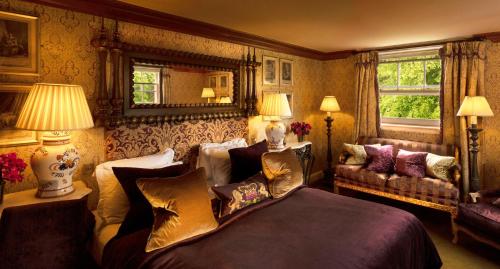 een slaapkamer met een bed en een bank bij Prestonfield House in Edinburgh