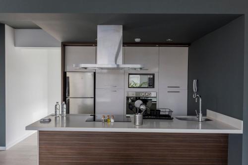 uma cozinha com um balcão branco e um frigorífico em Monochromatic 2BR in Miraflores em Lima