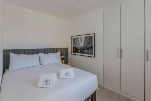 um quarto com uma cama branca com duas almofadas em Monochromatic 2BR in Miraflores em Lima