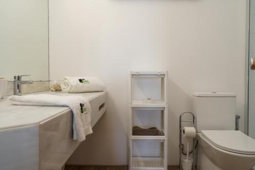 a bathroom with a sink and a toilet and a mirror at BmyGuest - Quinta do Lago Terrace Apartment I in Quinta do Lago