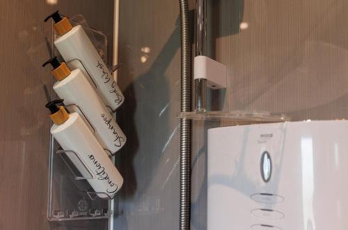 a group of five white electric toothbrushes hanging on a wall at Coleil Cottage in Garrabost