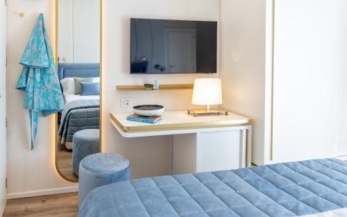 a bedroom with a bed and a tv and a table at Hotel Tiffany's in Riccione