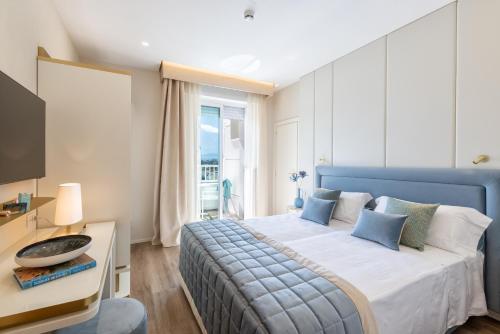 a bedroom with a blue bed and a window at Hotel Tiffany's in Riccione