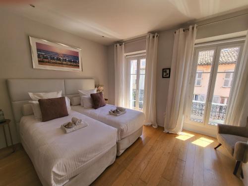 1 dormitorio con 2 camas y ventana grande en Villa Terra by Festif Azur - House 250m2 Quiet, 5 min walk from Palais des Festivals and Beaches en Cannes