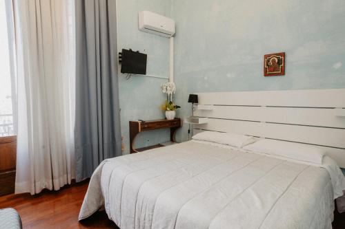 a bedroom with a white bed and a television at Villa Luigi XVI in Taranto