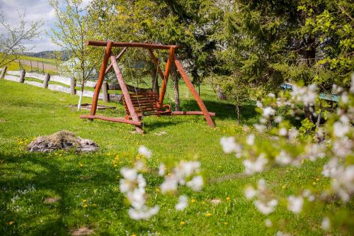 a playground in a field of grass with flowers at Domek Bogdanka in Polańczyk
