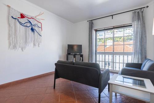 a living room with a couch and a tv at Apartamento Triana in Alenquer
