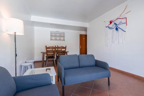 a living room with two blue chairs and a table at Apartamento Triana in Alenquer