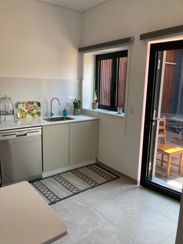 a kitchen with a sink and a door to a patio at CASA ANJOS in Amarante