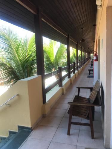 a hallway with benches and palm trees in a building at Riviera de São Lourenço Amarilis 302 in Bertioga