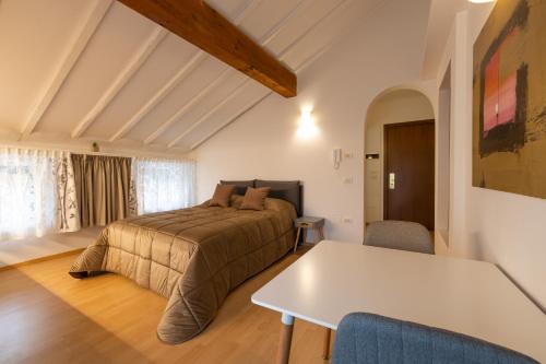 a bedroom with a bed and a table at Monolocale adiacente al centro con posto auto in Schio