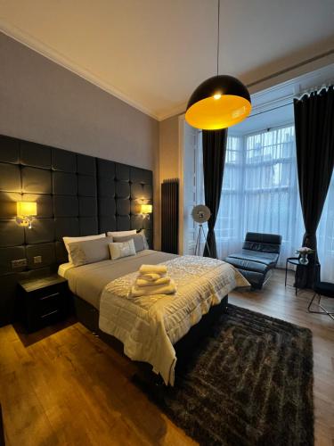 sypialnia z dużym łóżkiem i dużym oknem w obiekcie Amani Apartments - Glasgow City Centre w Glasgow