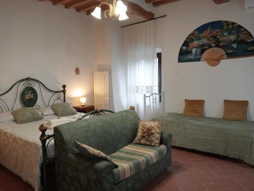a bedroom with a couch and a bed and a chair at B&B A Casa Mia in Pisa