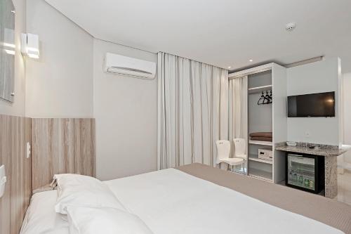 a hotel room with a bed and a television at Slaviero Ingleses Convention in Florianópolis
