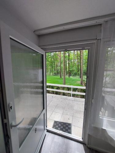 a sliding glass door with a view of a yard at Ferienbungalows am Wolziger See in Heidesee