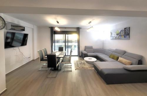 un soggiorno con divano e sala da pranzo di Dual Delights- Romantic Jacuzzi Suite and Spacious Family Apartment-Metro station 180m ad Atene